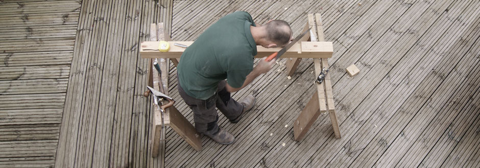 A carpenter sawing wood